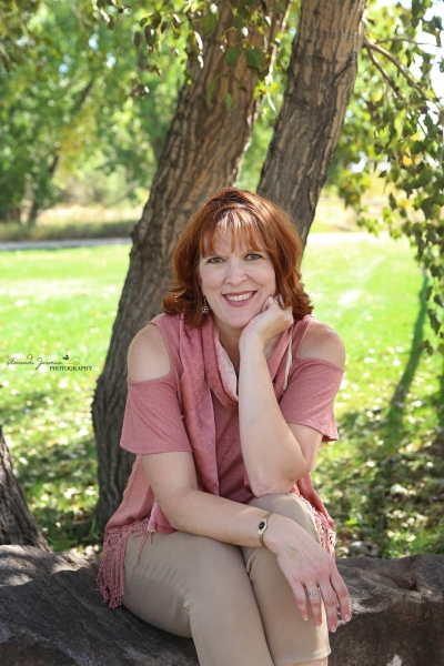 Loni Beall, licensed professional counselor, outdoors, sitting under a shade tree