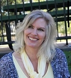 Lisa Geisterfer, licensed professional counselor, with a big smiles, sitting outdoors