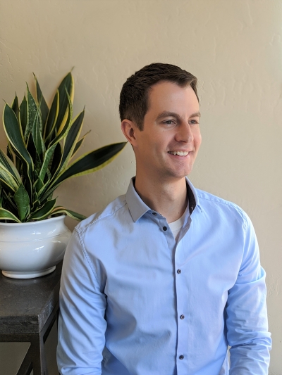 Ben Smith, licensed professional counselor at Evolve Counseling Services, smiling, wearing a light blue, long-sleeved button-up shirt