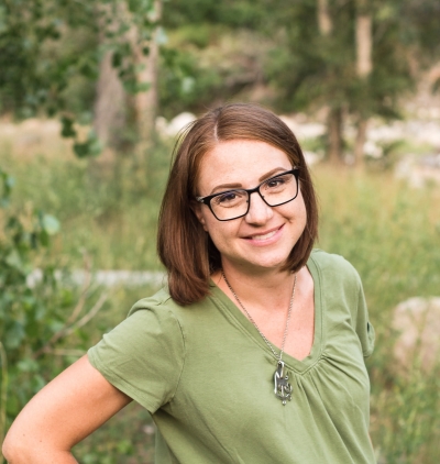 Rachel Lucas, licensed professional counselor and certified addiction specialist, smiling, standing outdoors, wearing glasses and with shoulder-length brown hair.