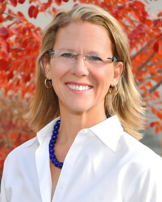 Jennifer Roberts, PhD, licensed clinical psychologist, smiling, wearing glasses, a white button-up shirt and a bright blue necklace