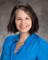 Stephanie Carroll, licensed clinical social worker, smiling, with dark hair, wearing a blue shirt