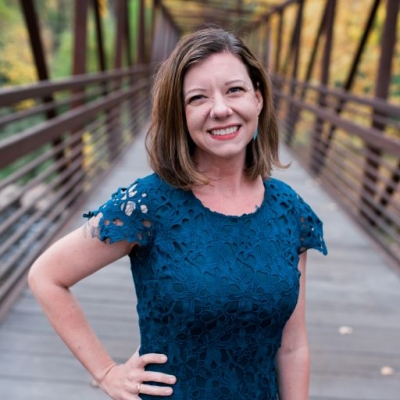 Emily Straw, licensed professional counselor, licensed addiction counselor, standing on a bridge, smiling