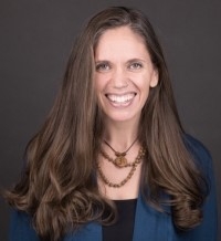 Jessica Link, licensed clinical social worker, smiling with long dark hair, wearing a black shirt and medium blue jacket