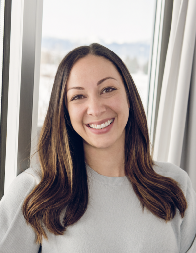 Emery Erhart, licensed professional counselor, smiling, standing indoors in front of a window