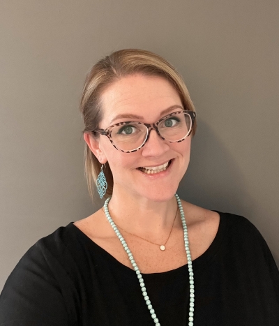 Tracy Main, licensed professional counselor, registered play therapist, smiling, wearing glasses and a black shirt