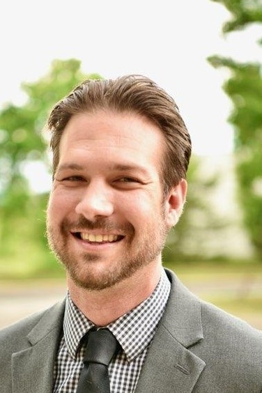 Casey Knight, licensed professional counselor, smiling, wearing a sports jacket, shirt, and tie
