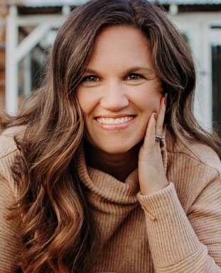 Brittany Brevard, licensed professional counselor, smiling, wearing a tan cowl-neck sweater 
