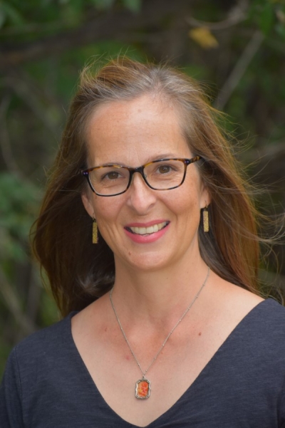 Amy Graver Beers, licensed clinical social worker, smiling, wearing glasses and a dark blue shirt