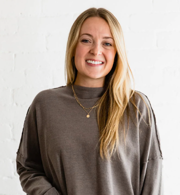 Hannah Hinchsliff, licensed clinical social worker, smiling, wearing a grey/brown top standing against a white background