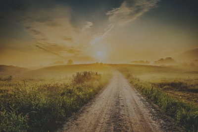 Picture of a dirt road leading toward a beautiful sunset