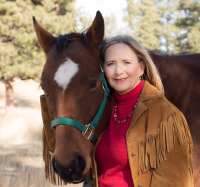 Suzanne Carter, licensed professional counselor, standing with her horse, Harmony