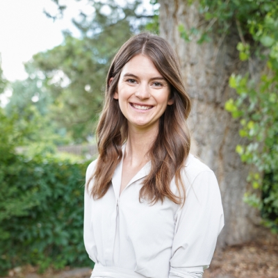 Alexis Ryan, licensed professional counselor candidate, smiling, standing outdoors in front of a tree