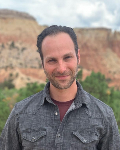 Matthew Beals, licensed professional counselor candidate, standing outdoors with trees and rock cliffs in the background