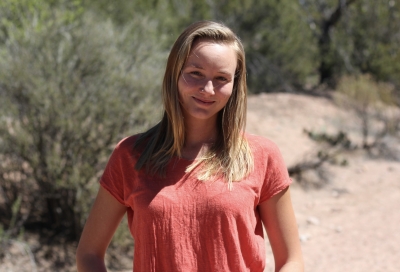 Courtney Blackmer-Raynolds, clinical social work candidate, wearing an orange top, standing outdoors