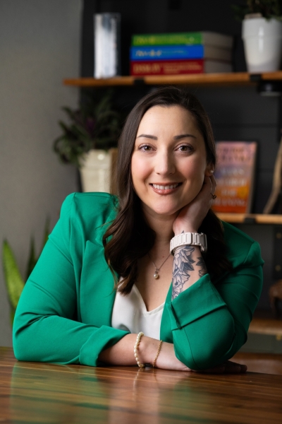 Stephanie Williams, licensed professional counselor, licensed addiction counselor, smiling, sitting at a table wearing a light green jacket and white shirt