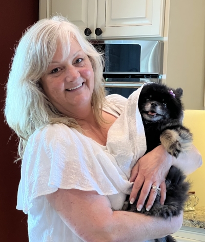 Leigh Ann Gerk, licensed professional counselor, smiling, holding a small black dog