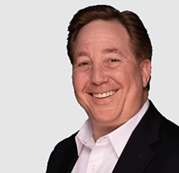 Chris Berger, licensed professional counselor, smiling, wearing a white button up shirt and black jacket against a light gray background
