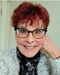 Pamela McCracken, licensed clinical social worker, wearing dark-rimmed glasses, smiling, with reddish hair