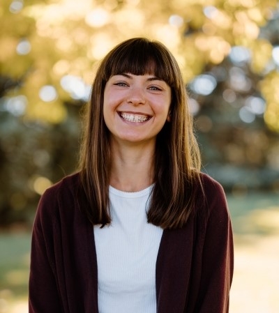 Amy Tuttle, licensed clinical social worker, smiling, wearing a white shirt and reddish brown sweater