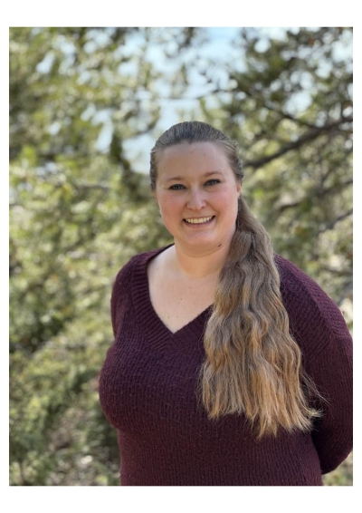 Rebecca Hoke, licensed clinical social worker, wearing a maroon sweater, with trees in the background.