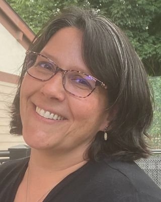 Jillian Busch, MD, wearing glasses and with a bright smile 