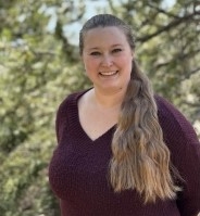 Rebecca Hoke, licensed clinical social worker, wearing a maroon sweater, with trees in the background