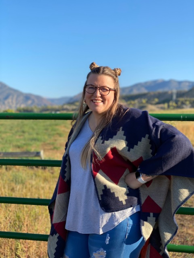 Whitney Walkenhorst, licensed clinical social worker, licensed addiction counselor, smiling, wearing glasses, standing outdoors, with a fence and hills in the background