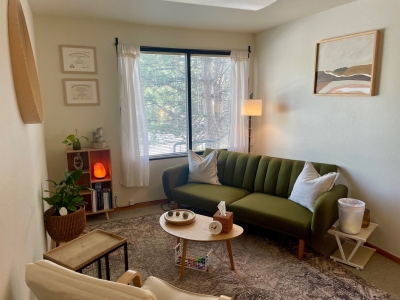 Office space with sofa and chair, a small coffee table, and large window