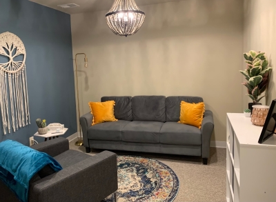 Office with sofa and comfortable chair, a plant and wall-hanging