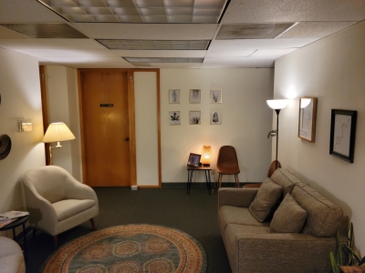 Lobby with a sofa, several chairs, floor lamps, and an area rug.