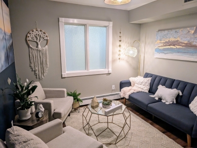 Well-lit office space with window, sofa, comfortable chairs, and a small table