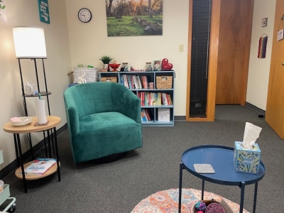 Office with comfortable chair, a small coffee table, bookcase, and floor lamp