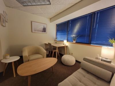 Office with sofa and chair, coffee table, and large windows