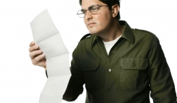 Male reading the fine print on a long document. 