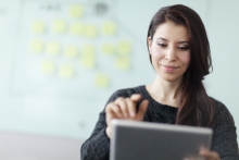 Female looking at a tablet, ready to make a decision. 