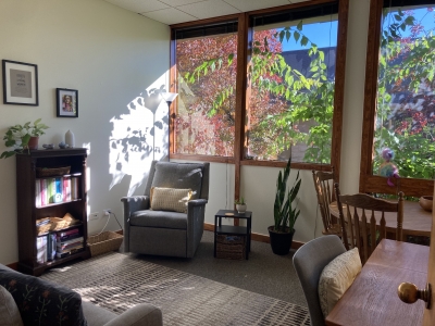 Therapy office with window, chairs, and desk.