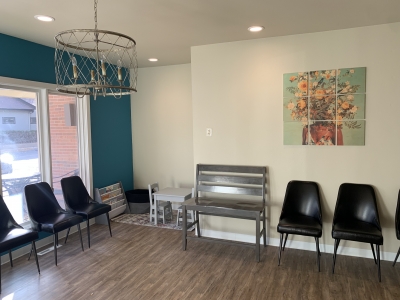 Waiting room with chairs along the wall and a large window