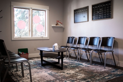 Waiting room, with chairs, area rug, coffee table, and 2 windows