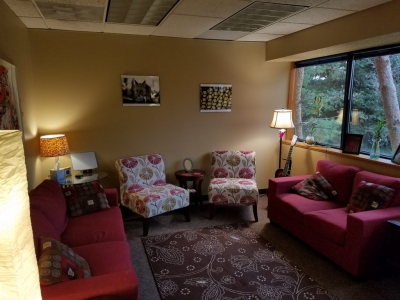 Office with two chairs, two couches, and a large window
