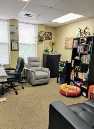 Oz Psychotherapy Office with chairs, large windows, and a bookcase