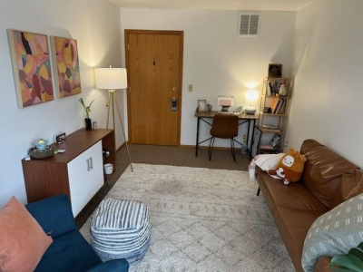 Office with sofa, chair, floor lamp, and desk with table lamp