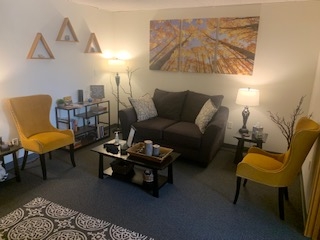 Private waiting room, with small sofa, chairs, coffee table, and floor lamps