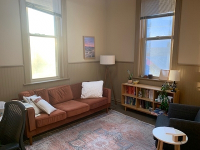Office with a sofa, large windows, and a bookcase