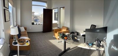 Office with large windows, sofa, chair 