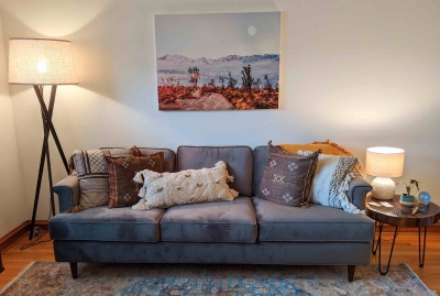 Shelly Annameier's office space, with comfortable sofa, pillows, floor lamp and table lamp, area rug