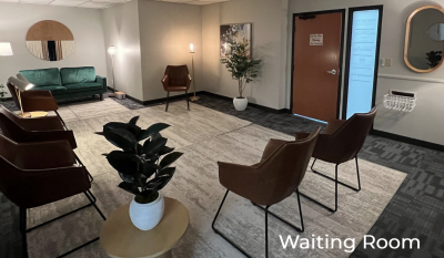 Waiting room with 4 chairs, a couch, and a couple of plants.