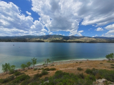 A view across Horsetooth Reservoir, with white clouds in a beautiful blue sky